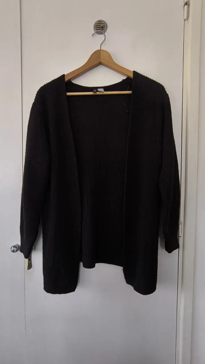 Cardigan negro de tejido grueso, ideal para usar en otoño e invierno. De la marca Divided de H&M, con un diseño abierto y mangas largas. Perfecto para un look casual y abrigado.