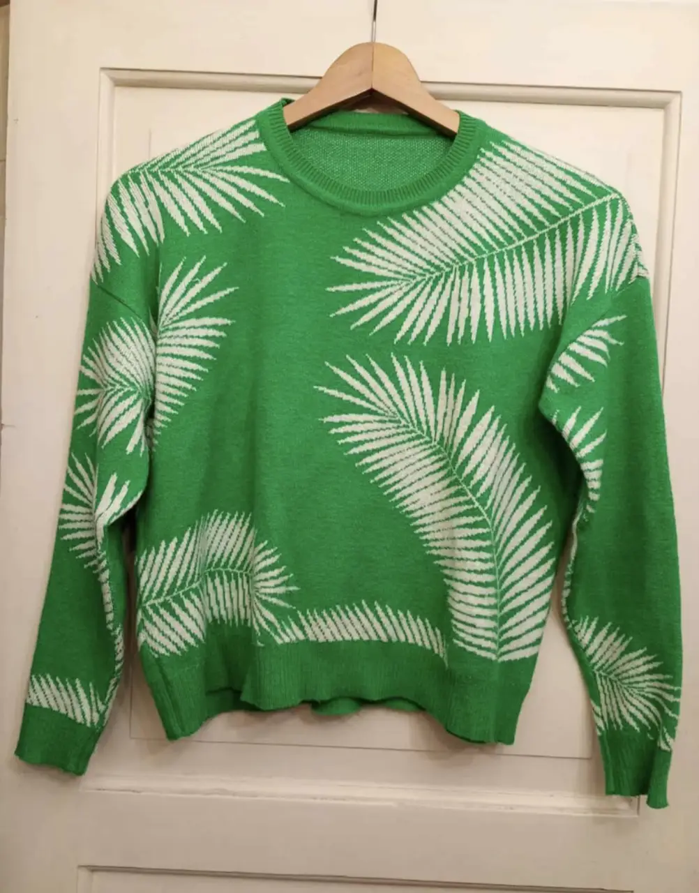 Sweater de color verde con estampado de hojas blancas. Ideal para un look casual y moderno.