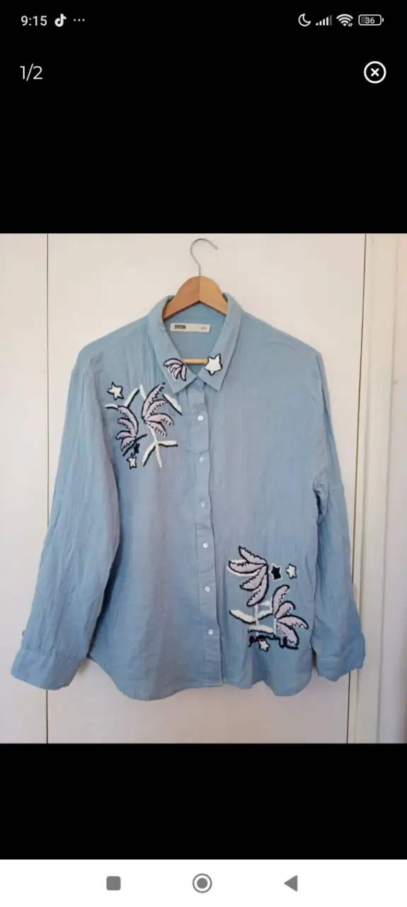 Camisa celeste con bordados de palmeras y estrellas. Ideal para un look casual y fresco.