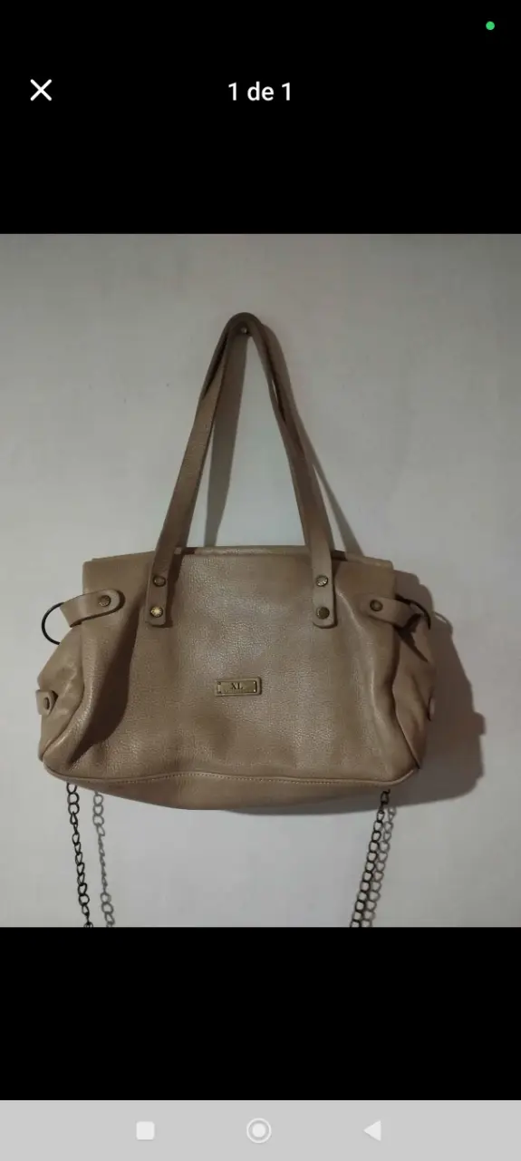Cartera de cuero color crudo marca XL, con detalles de diseño y cadena. Ideal para un look casual o de trabajo.