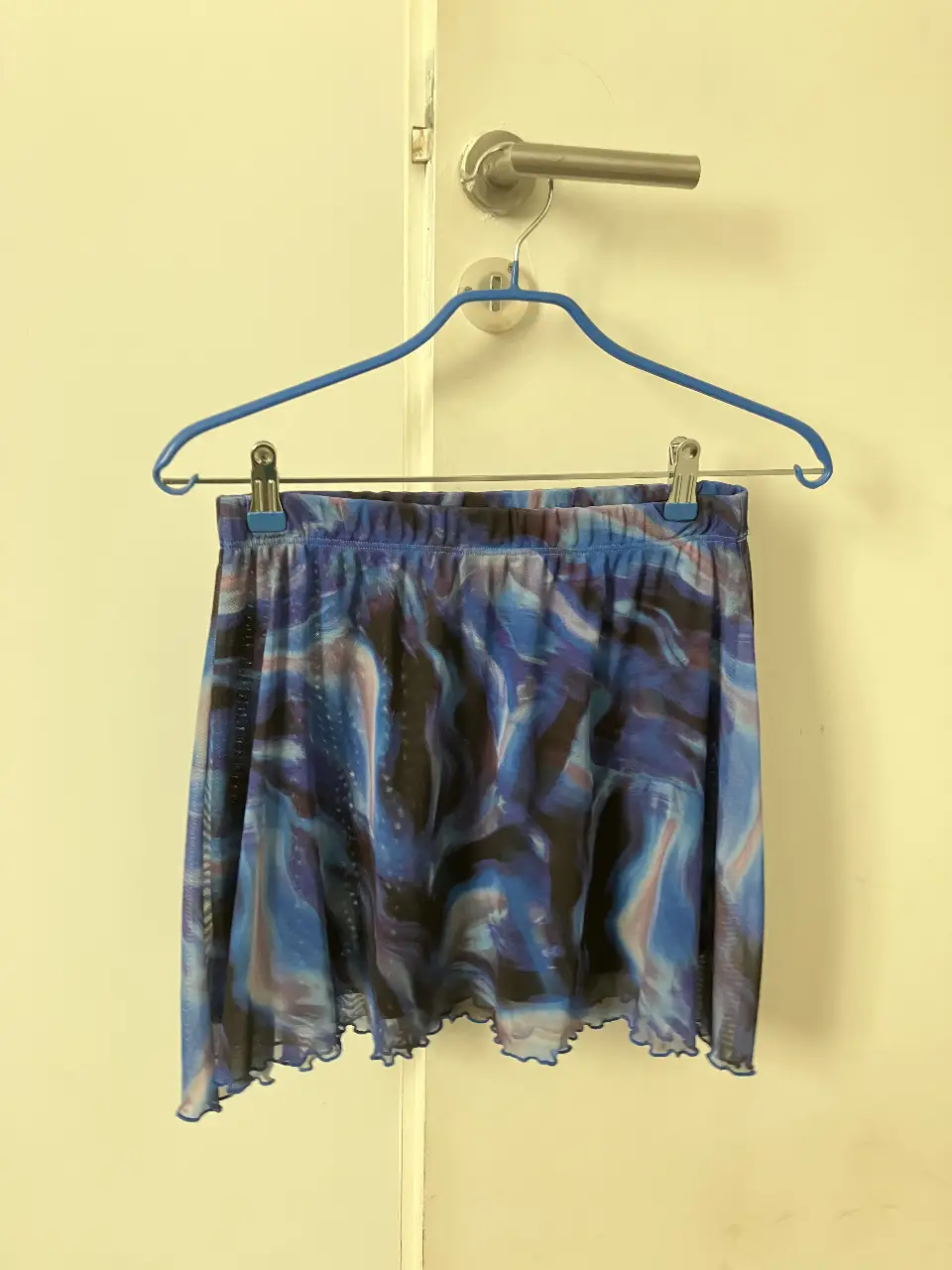 Minifalda de tul con estampado abstracto en tonos azules y negros. Ideal para un look de fiesta o rave.