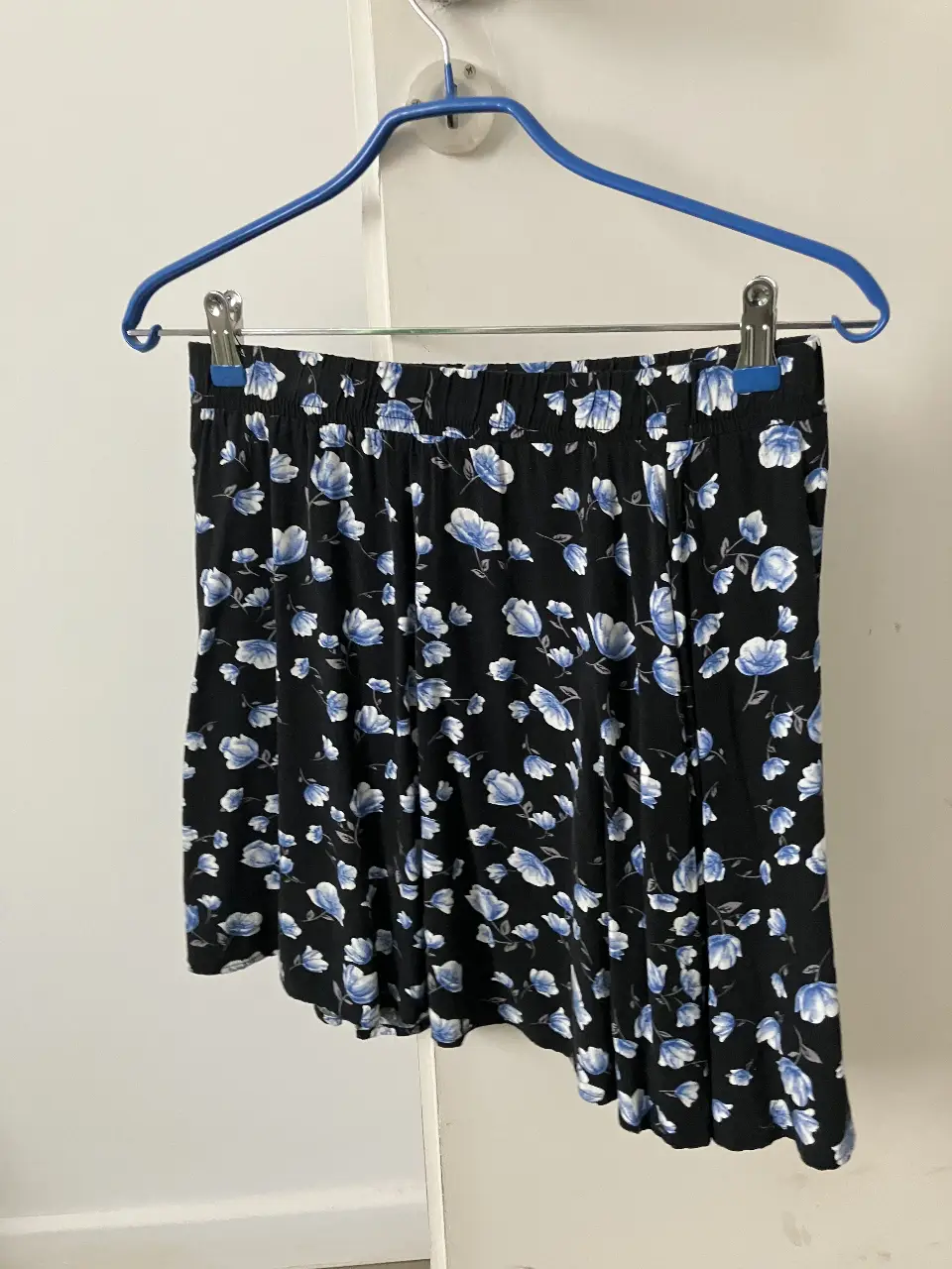 Pollera de Forever 21, con estampado floral en tonos azules y blancos sobre fondo negro. Ideal para un look casual y fresco. No es irregular, parece por la foto