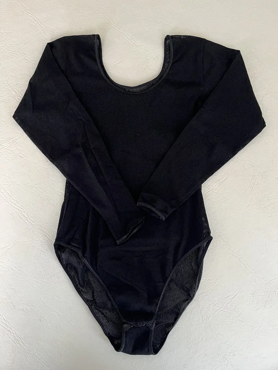 Body de manga larga negro. Confeccionado en tela de red transpirable y detalles en tela lisa. Perfecto para un look canchero de noche. 