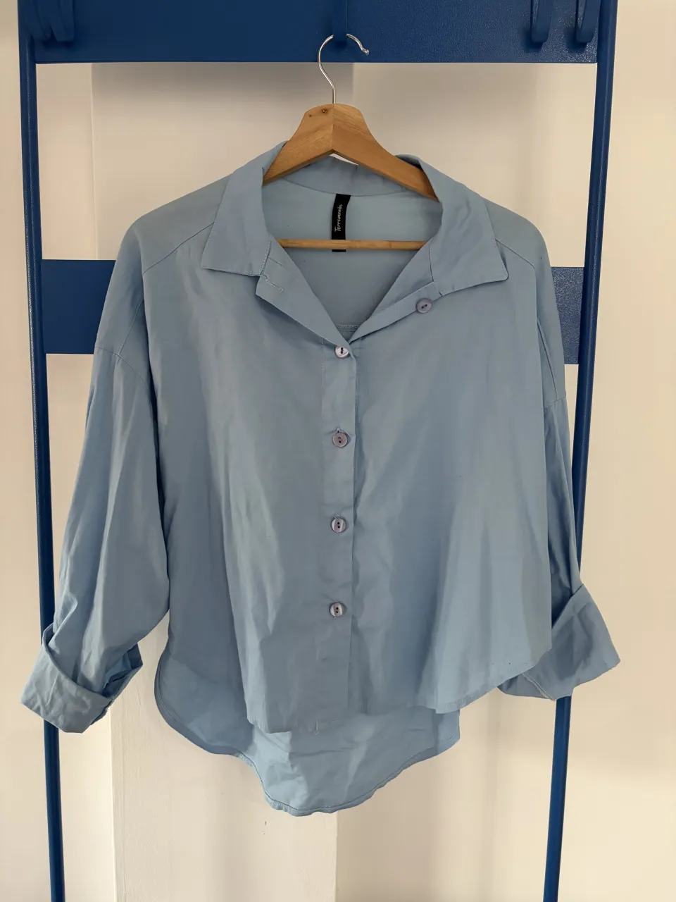 Camisa celeste de corte amplio, con botones al frente y cuello clásico. Mangas largas con puños doblados. Un básico versátil para cualquier ocasión. nueva!! 