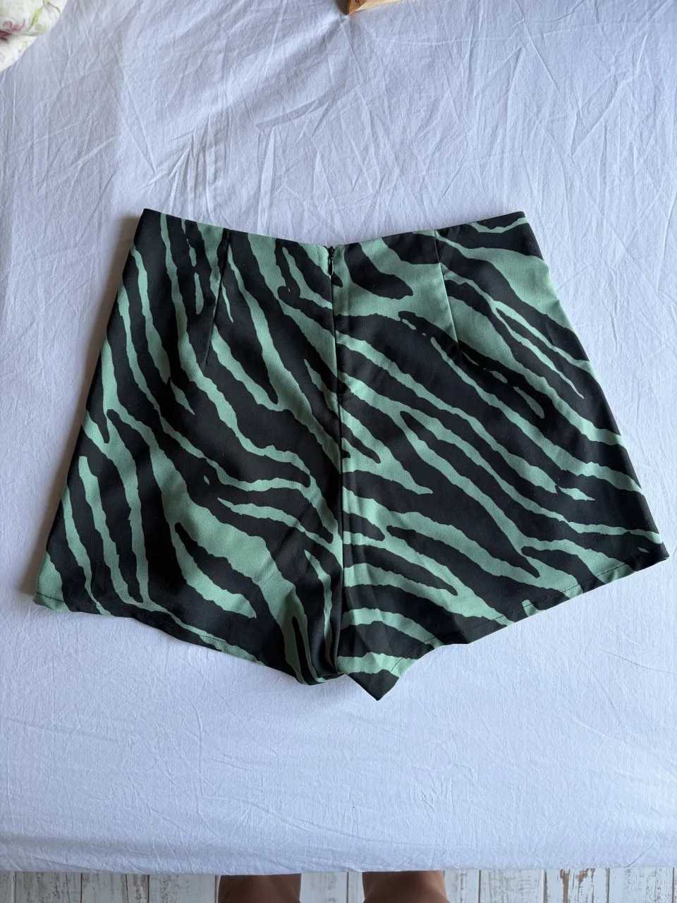 Shorts de tiro alto con estampa animal print de cebra en verde menta y negro. Diseño moderno y canchero, ideal para un look de verano.