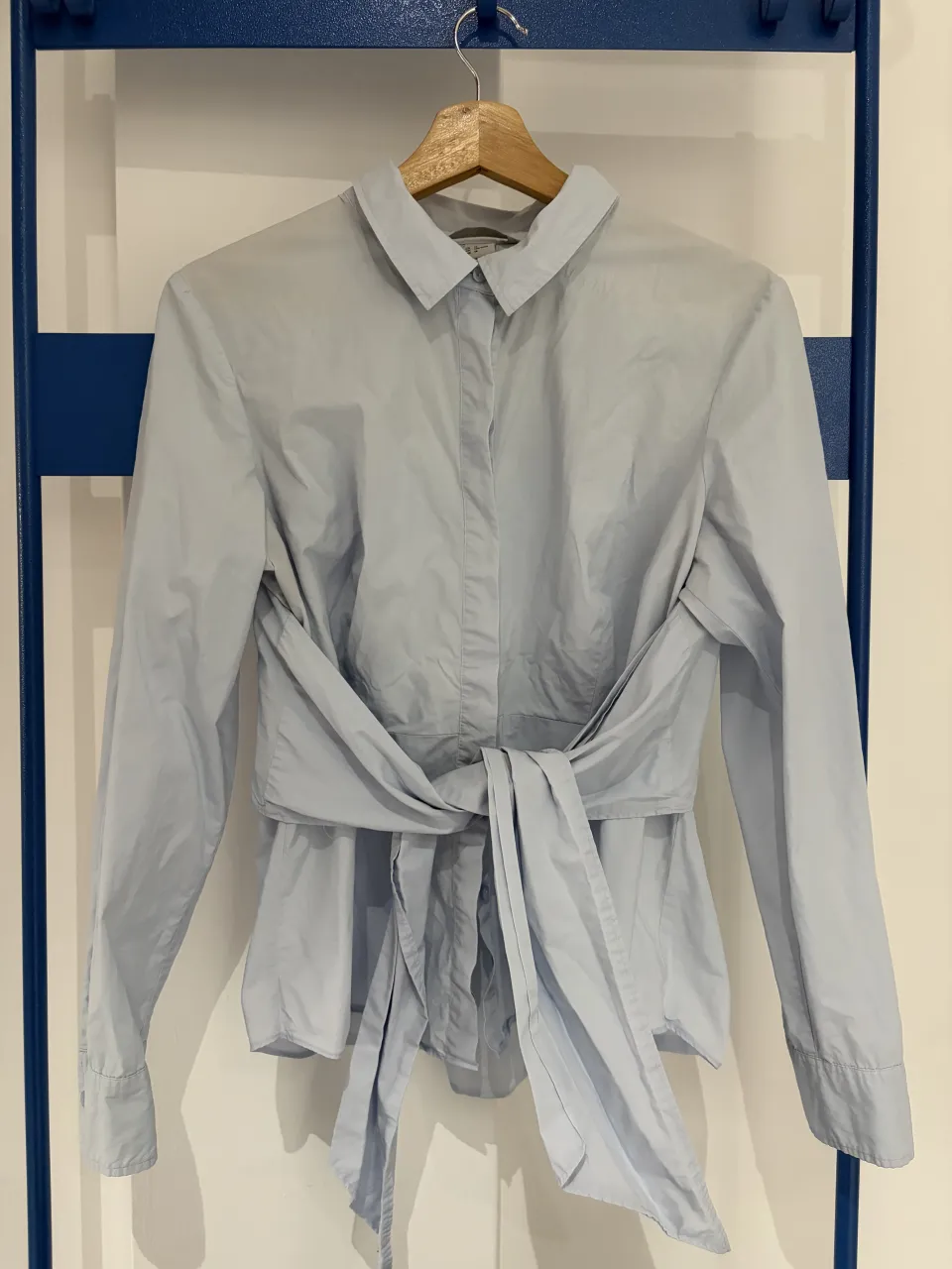 Camisa de vestir celeste con mangas largas y detalle de lazo en la cintura. Un modelo moderno y elegante, perfecto para un look sofisticado. hermosa!! 