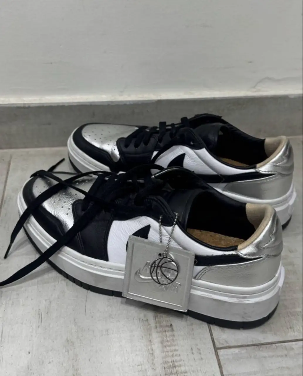 Zapatillas de mujer, estilo urbano, con detalles en plateado y negro. Diseño moderno y suela gruesa.