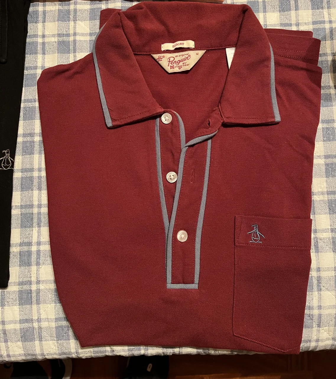Remera deportiva de hombre, color bordó con detalles en gris. Cuello polo con botones y bolsillo con logo bordado. Marca Penguin.