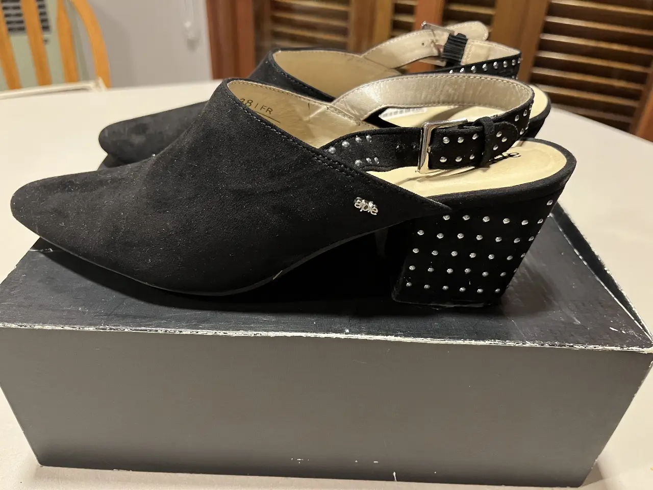 Zapatos de taco alto negros con detalles de tachas en el taco y en la tira del tobillo. Ideales para una fiesta o evento especial.