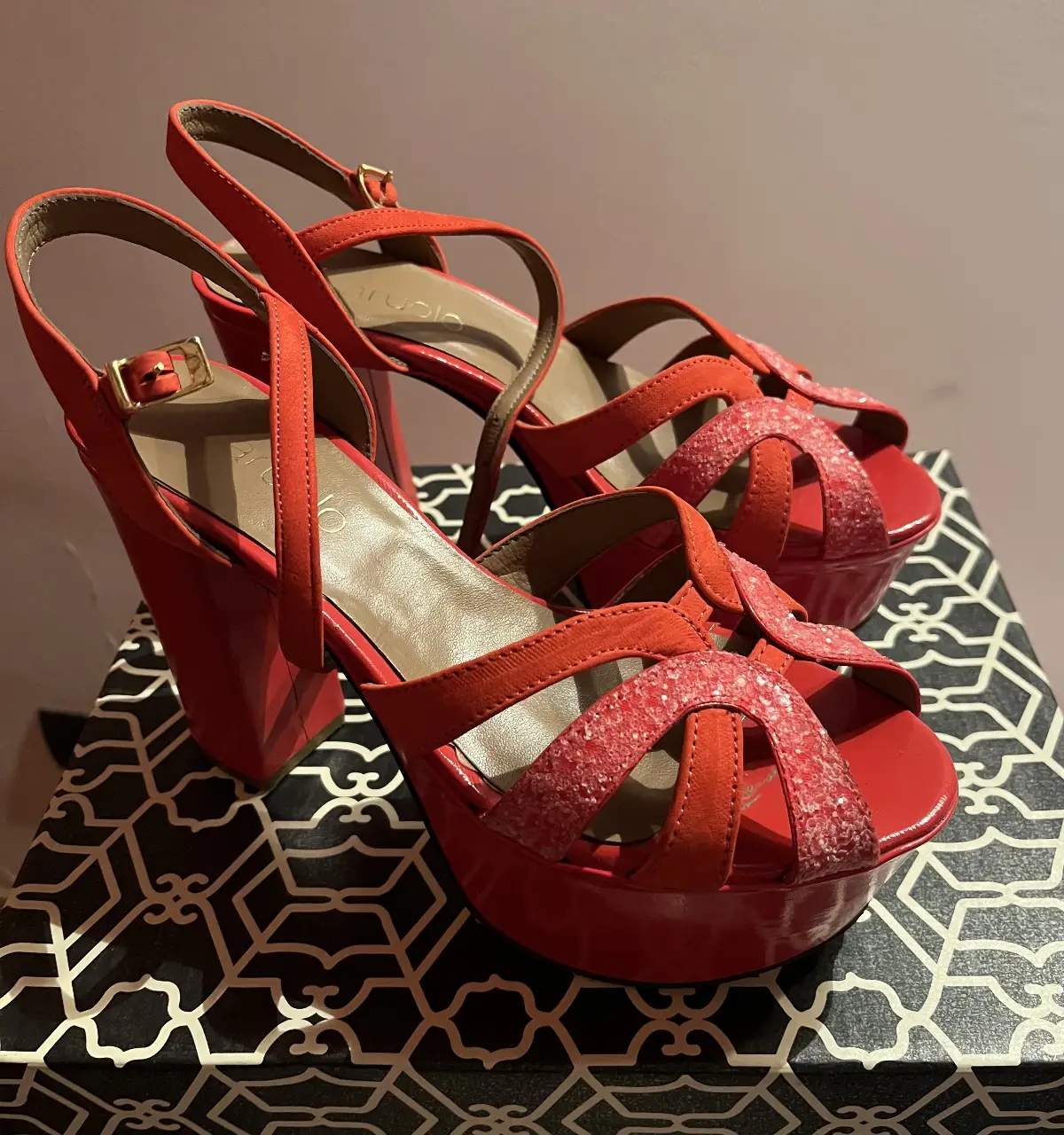 Sandalias rojas de plataforma con tiras cruzadas y hebilla en el tobillo. Ideales para darle un toque audaz a tus looks de fiesta o eventos especiales.