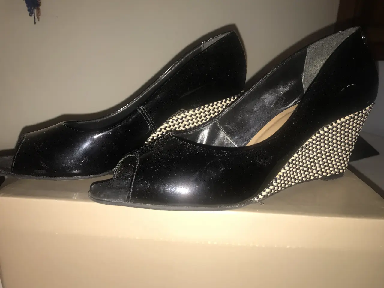 Elegantes zapatos de taco alto negros con diseño de cuña y puntera abierta. Ideales para eventos formales o salidas nocturnas.