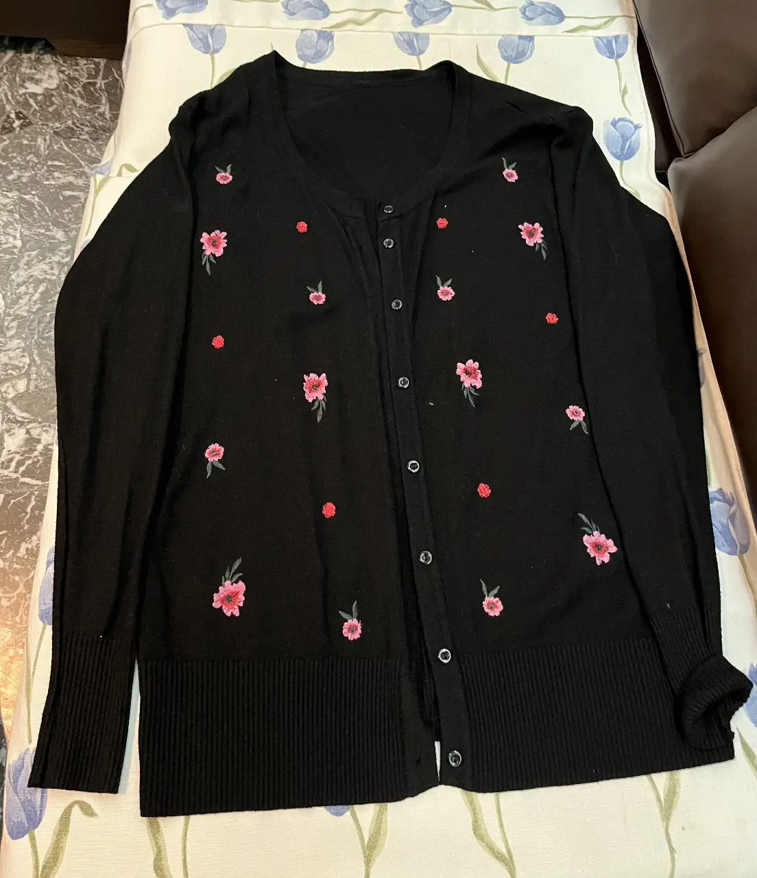 Cardigan negro de mujer con bordado floral en tonos rosas. Ideal para un look casual y femenino. Perfecto para combinar con diferentes outfits.