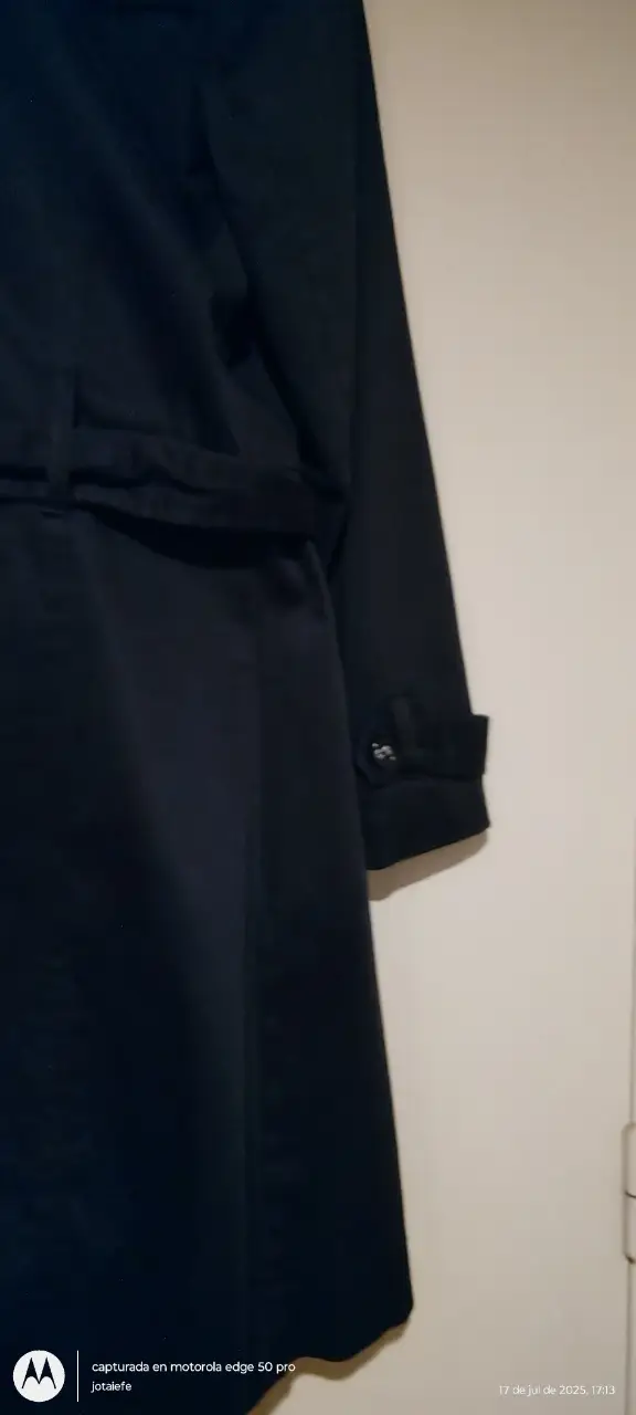Trench coat negro, clásico y elegante. Ideal para un look sofisticado y atemporal. Con cinturón para ajustar la cintura y resaltar la figura. Perfecto para cualquier ocasión.