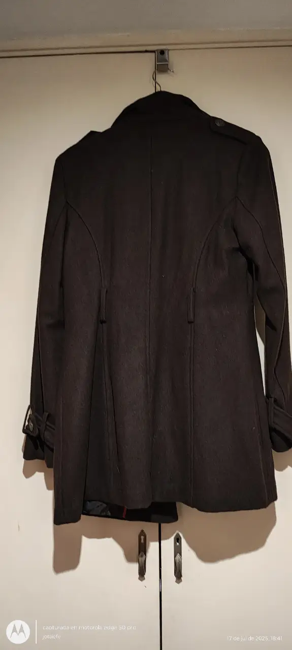 Tapado largo de color marrón oscuro, con cuello alto y botones. Ideal para el invierno, con un diseño elegante y atemporal (falta cinto)