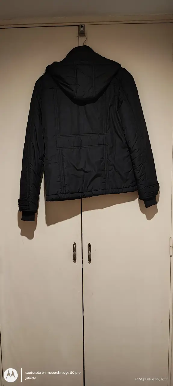 Campera negra con capucha, ideal para el invierno. Posee bolsillos y un diseño clásico. Perfecta para un look casual y abrigado.