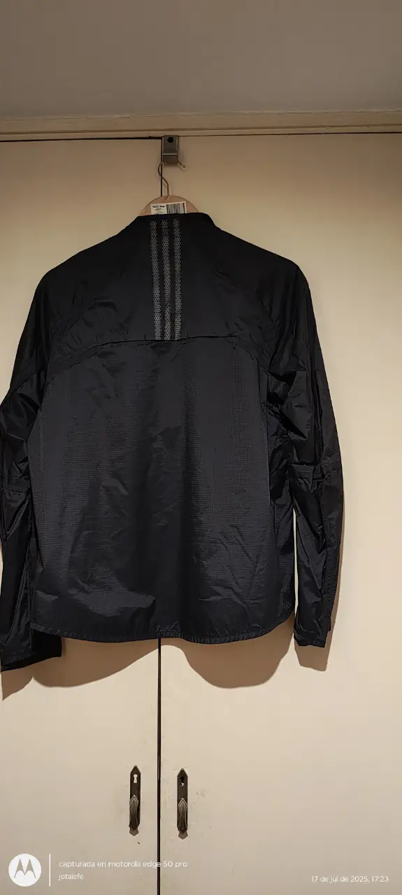 Campera deportiva Adidas negra con interior amarillo. Ideal para running o actividades al aire libre. Posee cierre y detalles de diseño.