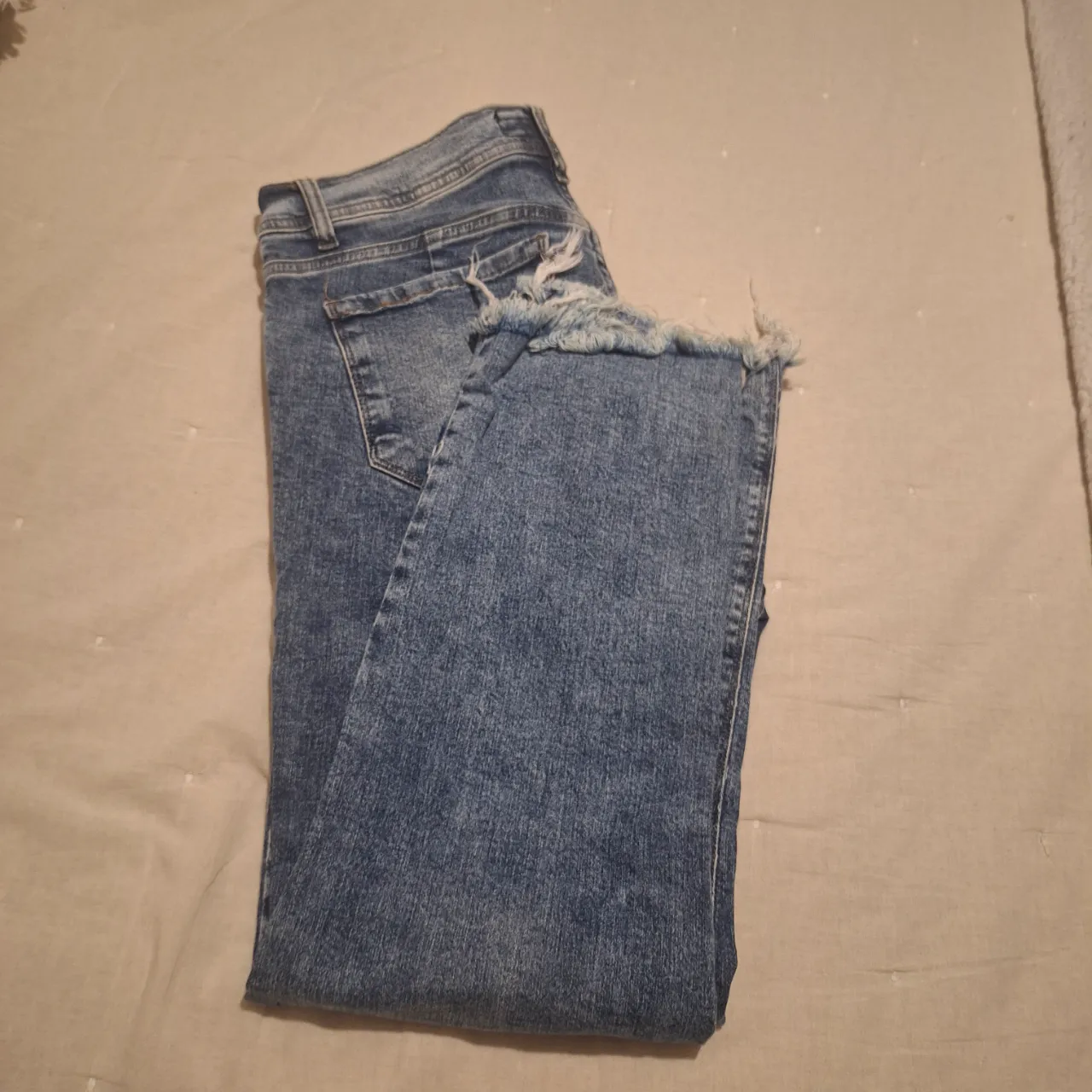 Jeans de mujer, tiro medio, con roturas en las rodillas y el bajo desflecado. Talle 46. Marca Cenitho Jeans.