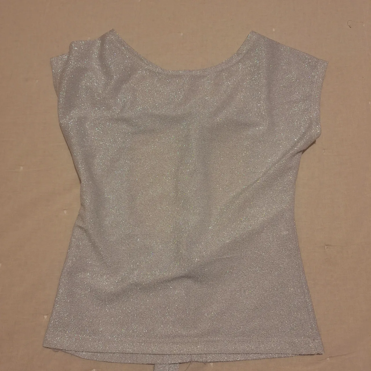 Top plateado con espalda descubierta y detalle de lazo. Ideal para fiestas y eventos especiales. Talle 38.
