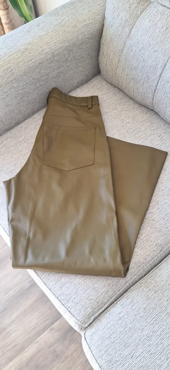 Pantalón sastrero de cuero sintético en color verde oliva. Tiro alto, corte recto y bolsillos traseros. Ideal para un look moderno y sofisticado.