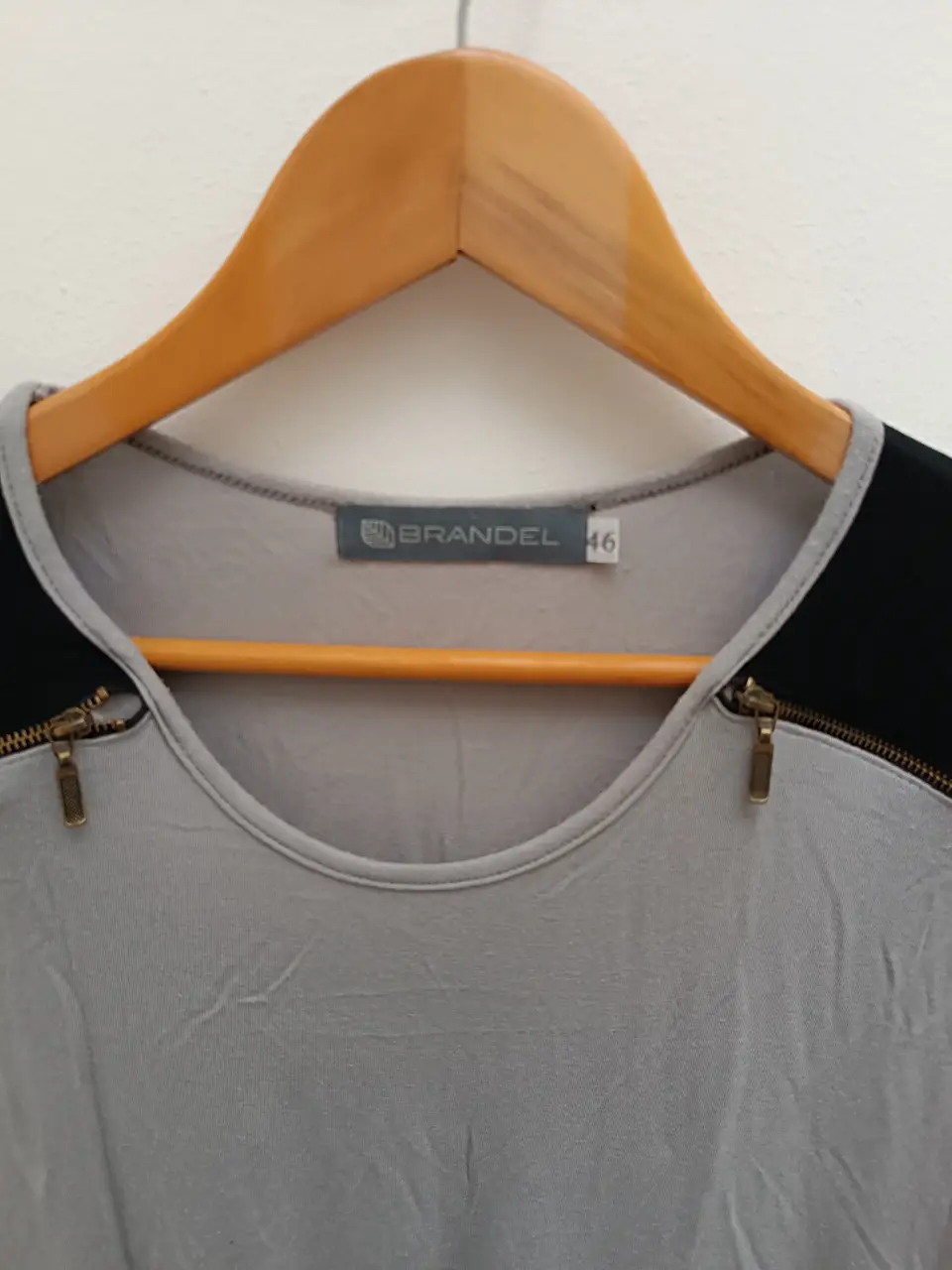 Remera manga larga gris con detalles en negro en los hombros y cierre decorativo. Talle 46 de la marca Brandel.