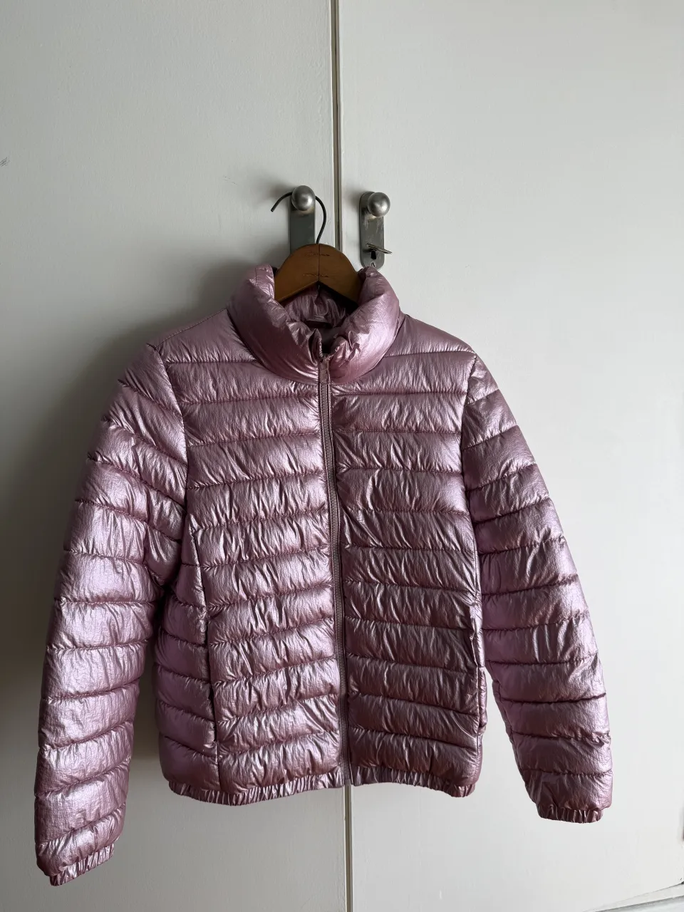 Campera acolchada rosa metalizada con cuello alto y cierre.