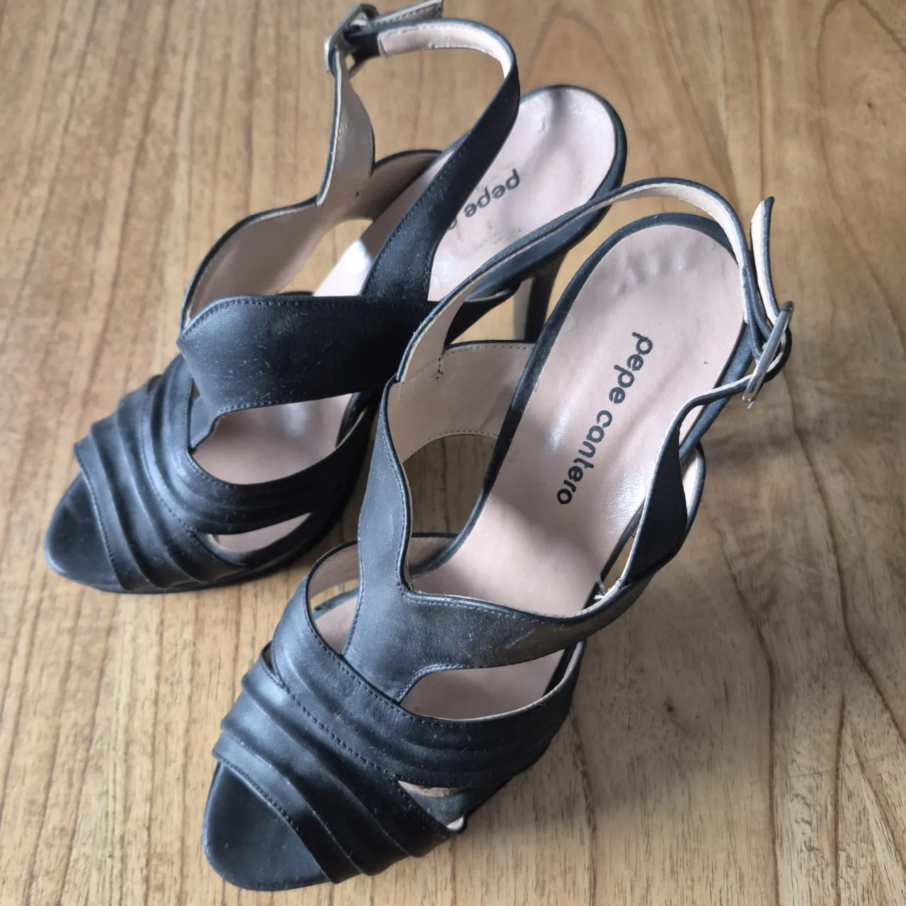 Sandalias negras de taco alto con plataforma y tiras cruzadas. Ideales para un look elegante y sofisticado.