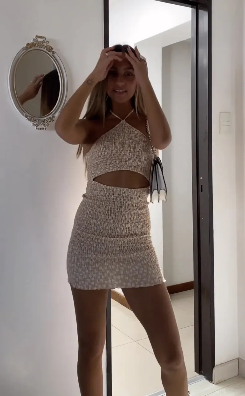 Vestido negro corto con estampado floral. Posee fruncido en toda la prenda y un recorte en la cintura. Breteles finos. 