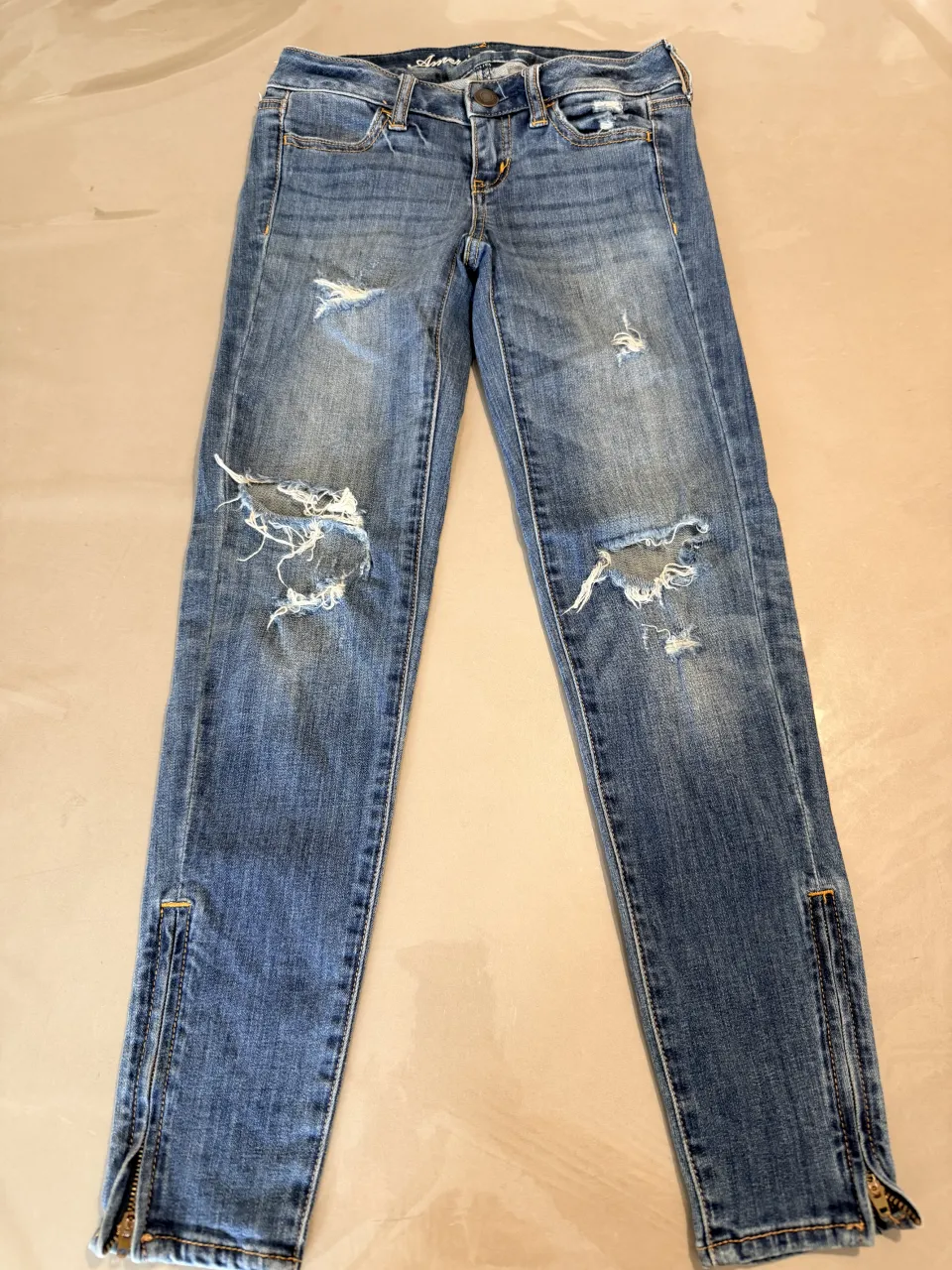 Jeans tiro alto con roturas y cierres en los tobillos. Un clásico que no puede faltar en tu guardarropa.