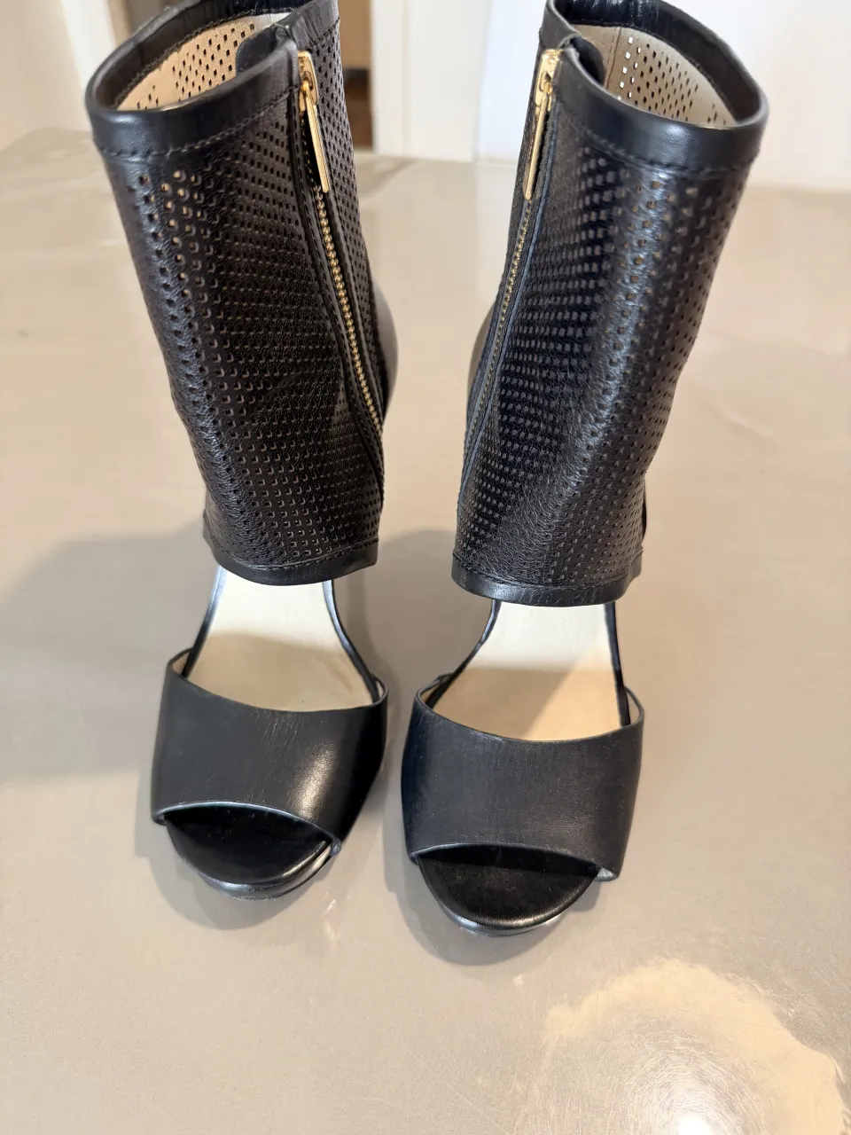 zapatos de cuero negros con diseño calado y cierre lateral. Ideales para darle un toque audaz a tus looks.