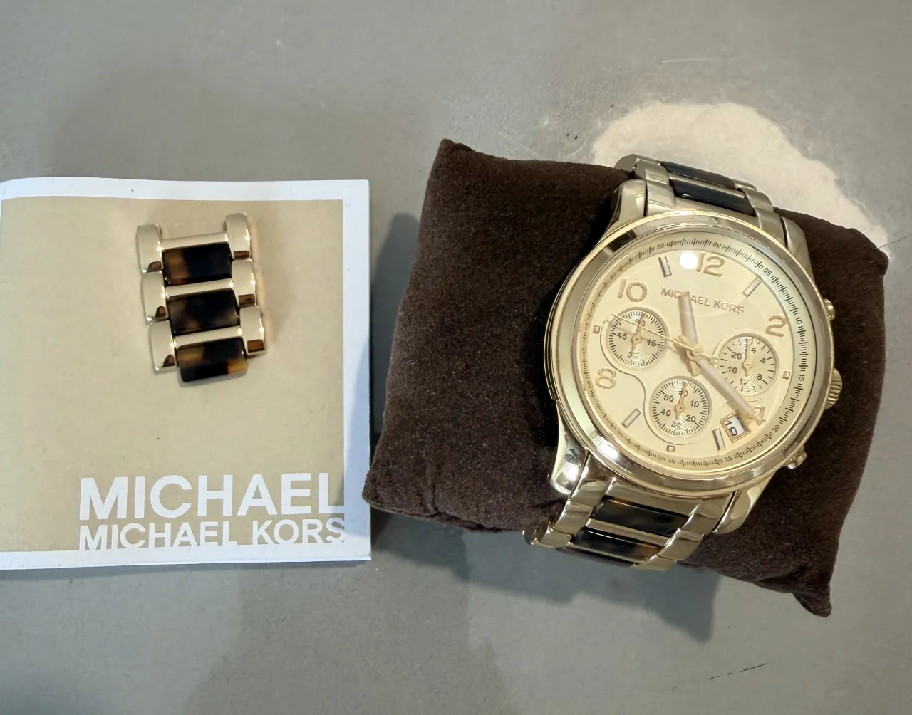 Reloj Michael Kors dorado con detalles en carey. Un clásico que nunca pasa de moda, perfecto para darle un toque de elegancia a cualquier outfit. Ideal para el día a día o para una ocasión especial.