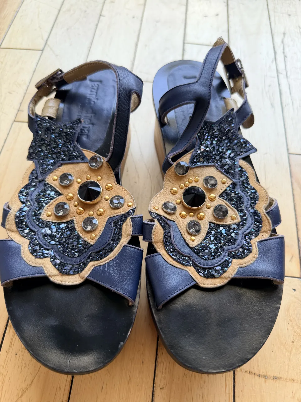 ¡Sandalias súper originales y llamativas con plataforma de madera! Tienen un diseño único con detalles brillantes y apliques que las hacen destacar. Perfectas para darle un toque especial a cualquier look.