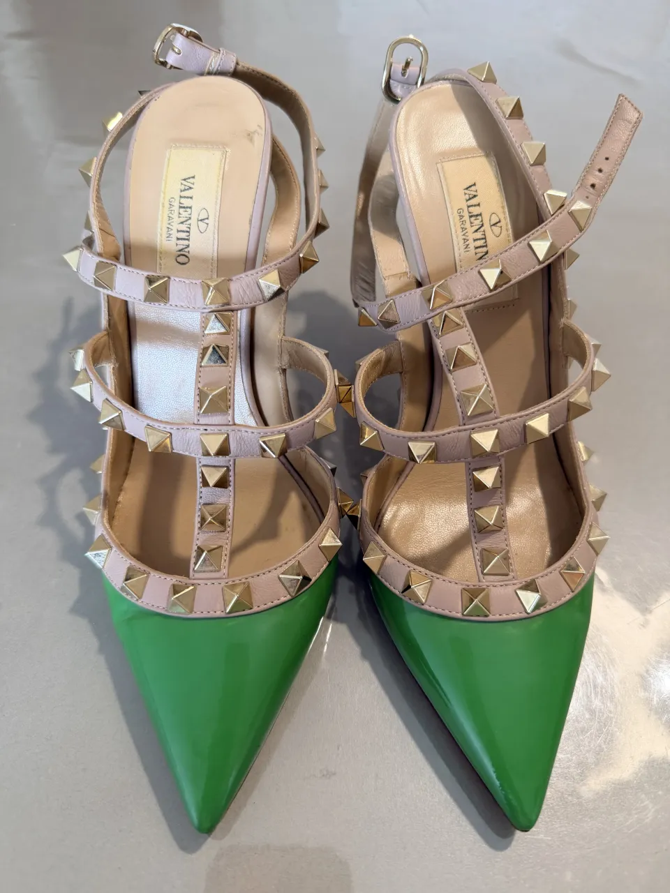 Zapatos de taco alto con tachas doradas y punta fina. Diseño elegante y audaz, perfectos para destacar en cualquier ocasión especial. El color verde vibrante de la punta contrasta con las delicadas tiras y tachas.