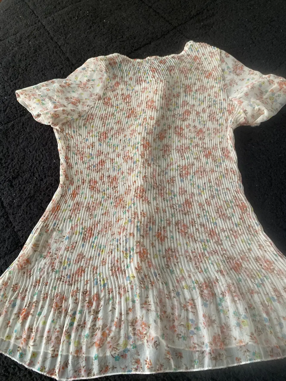 Blusa de mujer con estampado floral, diseño plisado y volantes en el frente. Ideal para un look fresco y femenino.