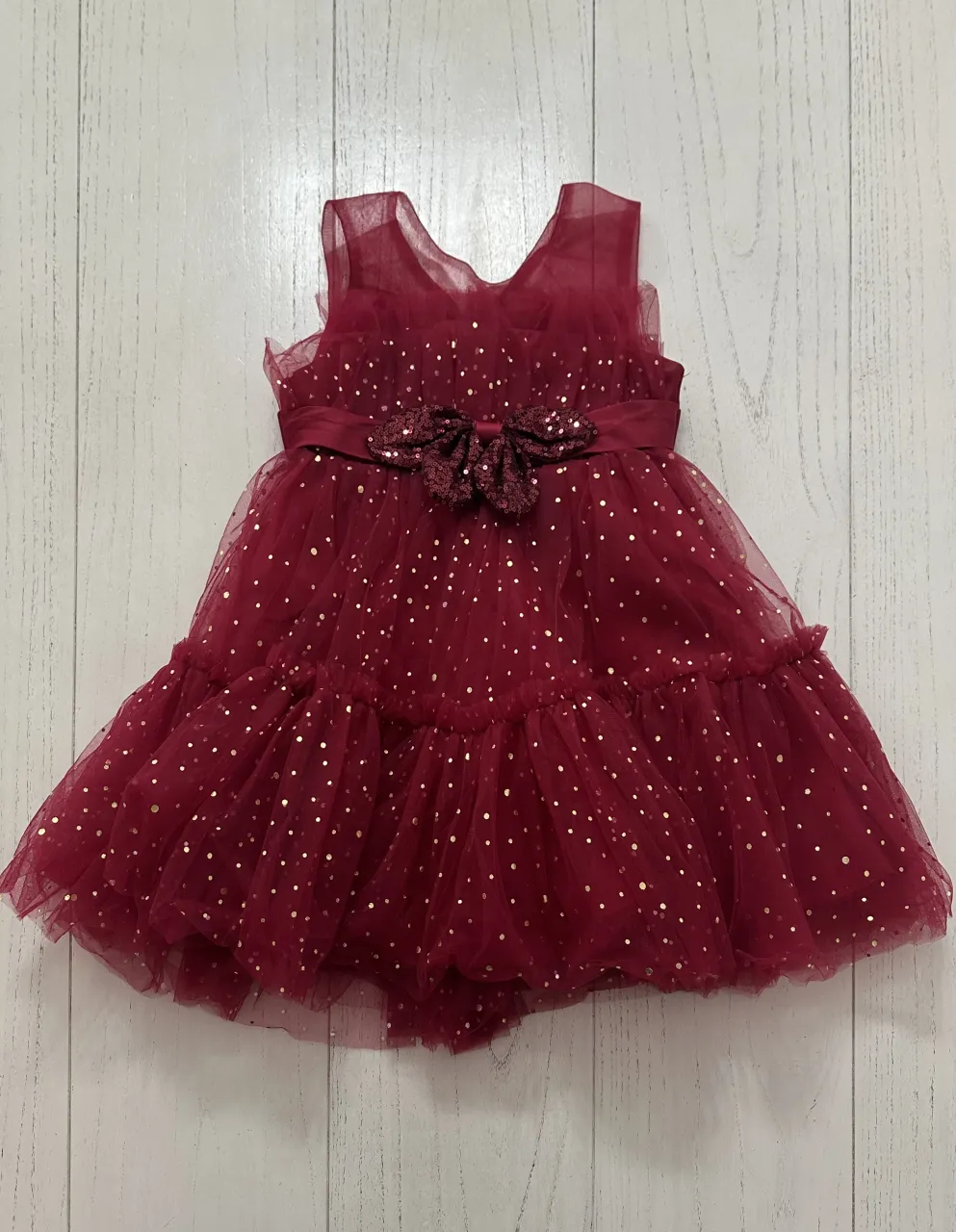 Vestido de fiesta de tul bordado con detalles dorados y lazo en la cintura.