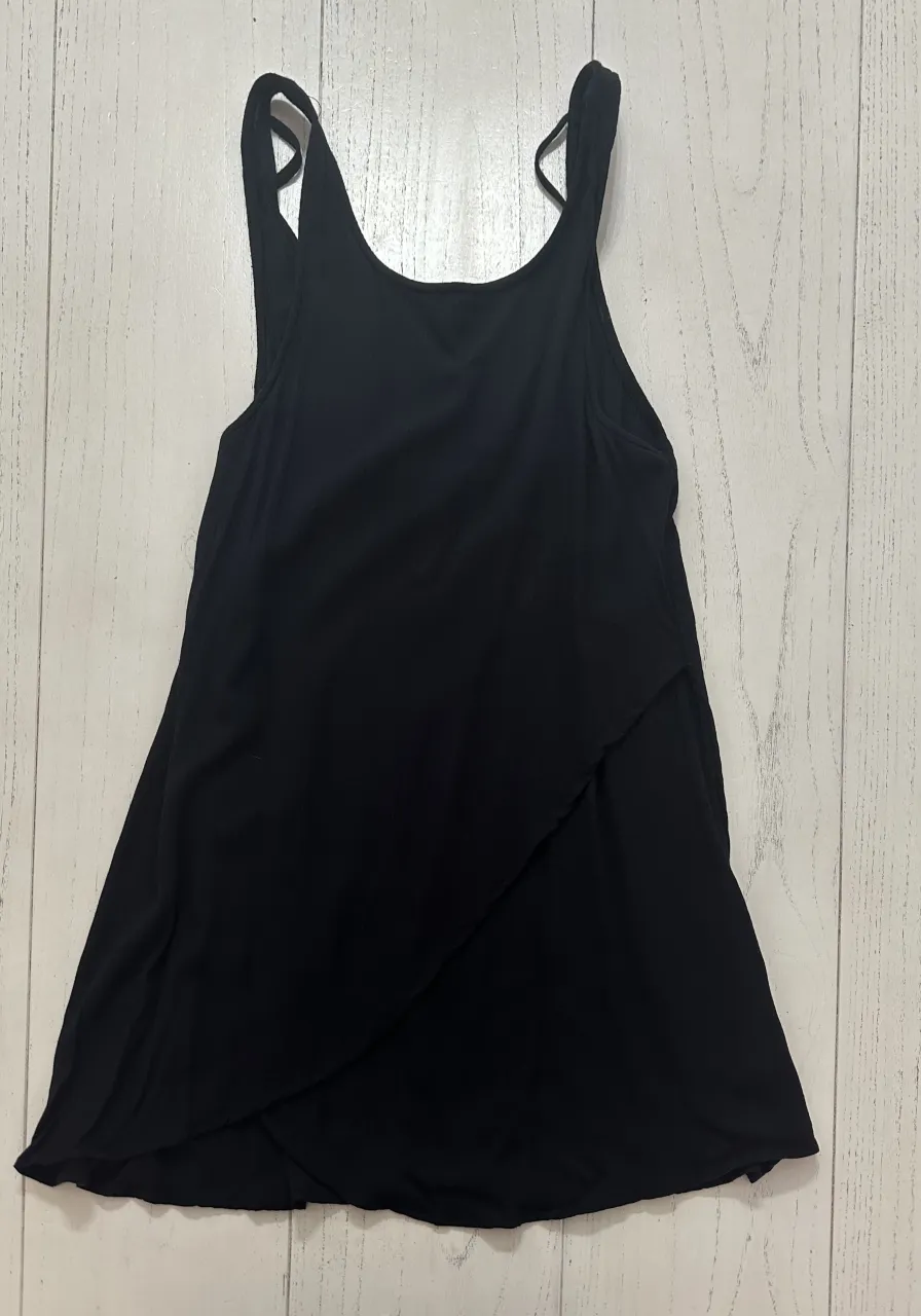 Musculosa negra con diseño cruzado en el frente y tirantes finos.