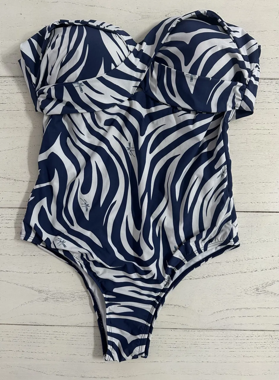 ¡Impresionante traje de baño entero con un audaz estampado de cebra en azul marino y blanco! Diseño strapless con mangas largas, ideal para lucir espectacular en la playa o la piscina. Su corte favorecedor y el estampado vibrante lo convierten en una pieza única para tus días de sol.