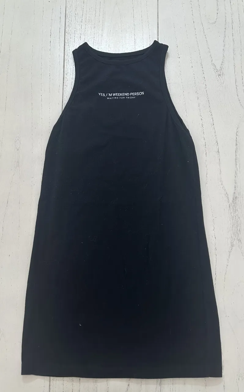 Remera negra sin mangas con estampa "YES, I'M WEEKEND PERSON WAITING FOR FRIDAY" en la parte superior.