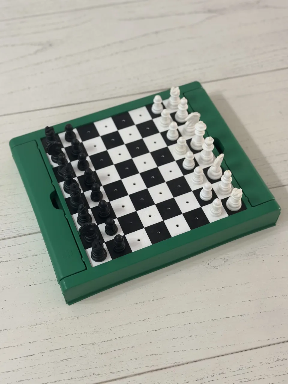 Mini ajedrez portátil con tablero plegable y piezas de ajedrez.