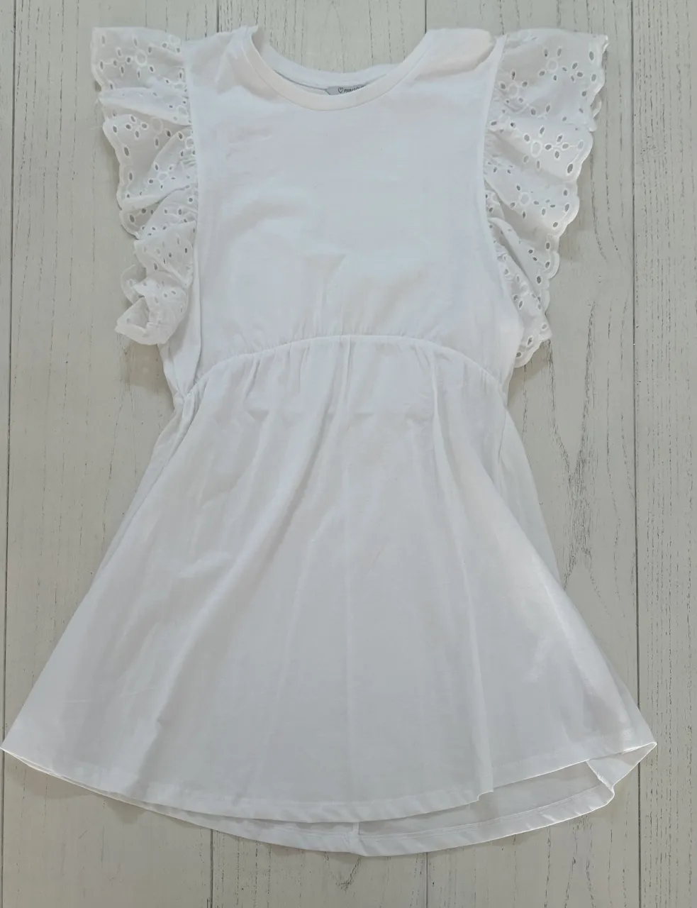 Vestido blanco con mangas cortas con volados y detalles de bordado. Cintura elastizada.