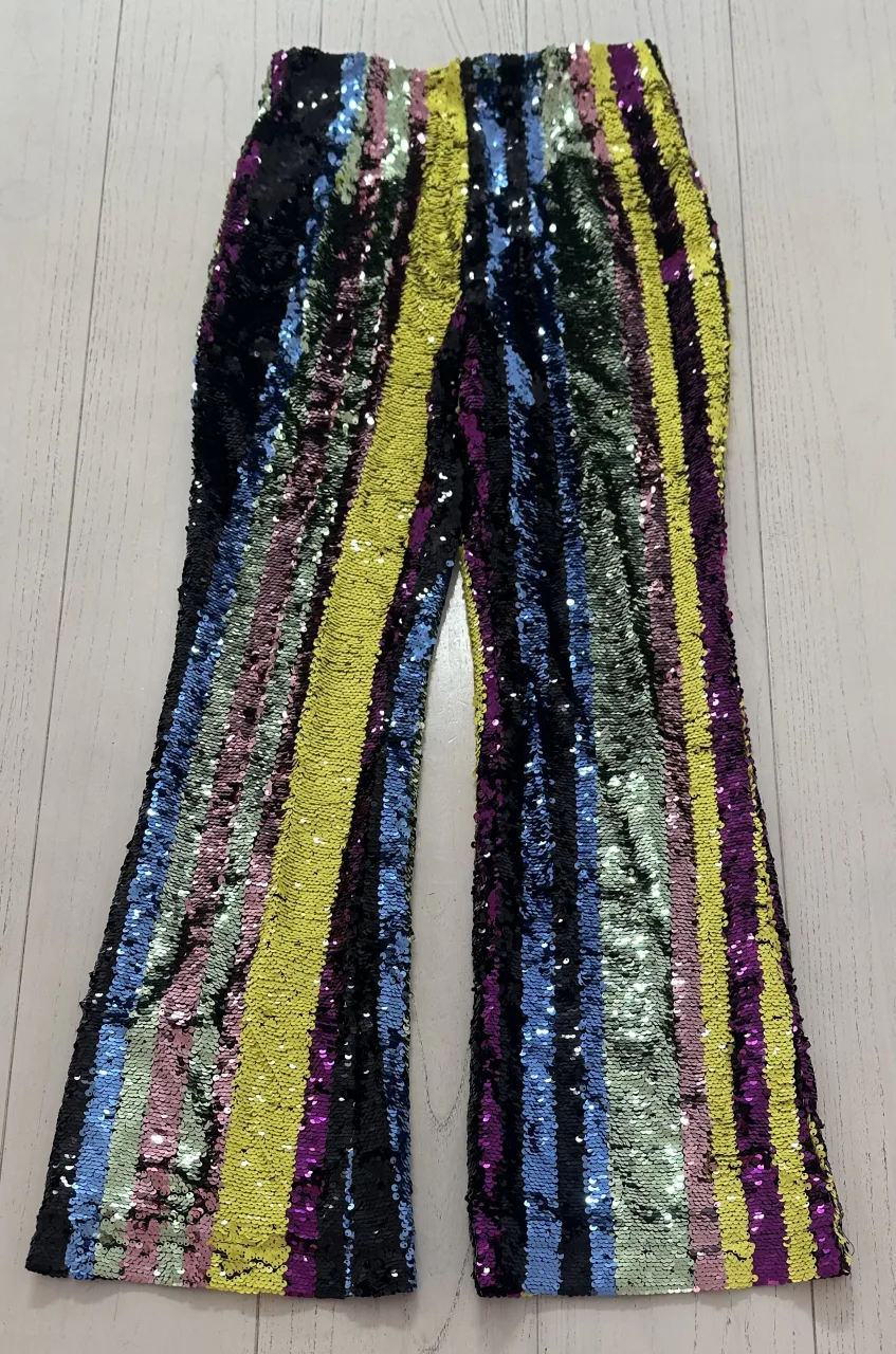 ¡Pantalones de fiesta súper llamativos con lentejuelas de colores vibrantes! Tienen un corte acampanado y son perfectos para destacar en cualquier evento o salida nocturna. ¡No te quedes sin los tuyos!