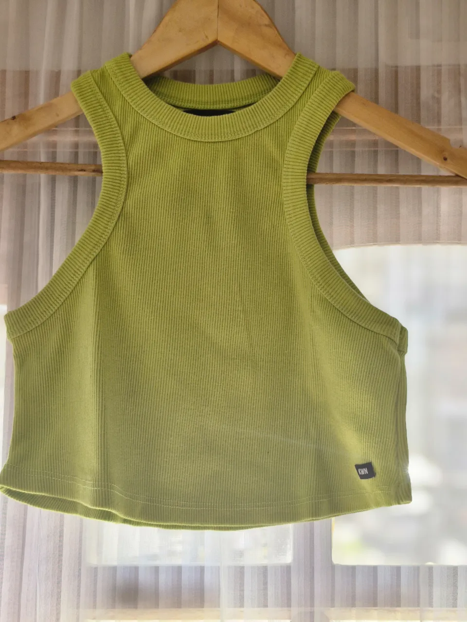 Top deportivo de color verde lima, con corte halter y detalle acanalado. Ideal para  looks casuales.