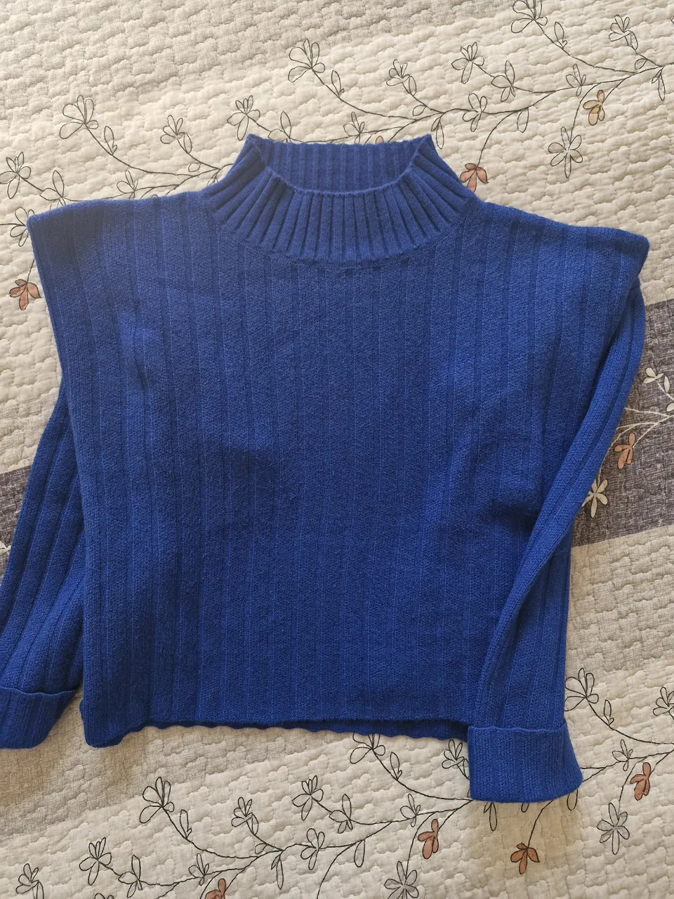 Sweater de cuello alto azul, tejido con textura acanalada. Ideal para un look casual y abrigado.