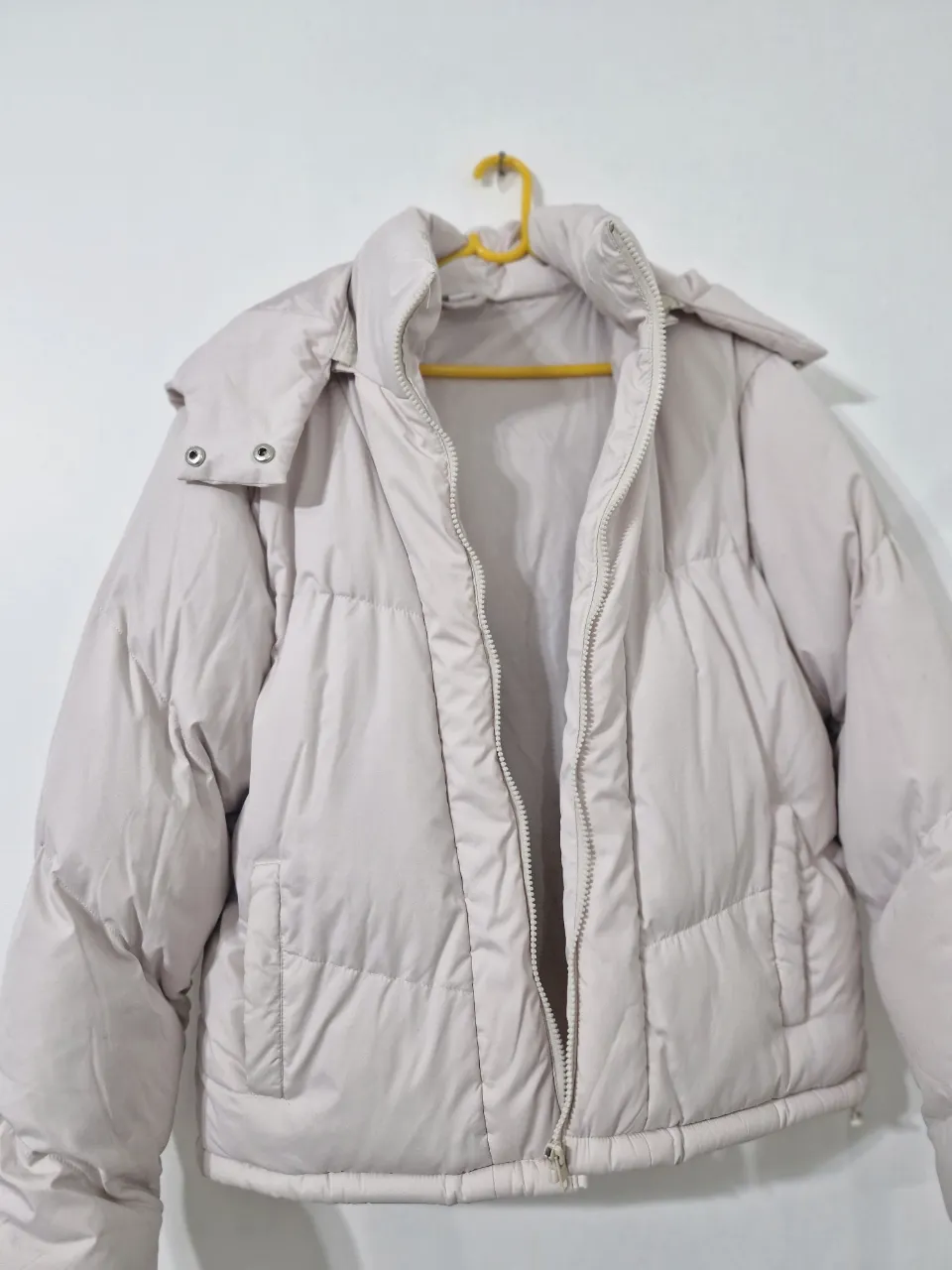 Campera acolchada en color crudo, con capucha y cierre frontal. Ideal para el invierno. Bolsillo interno, cordón inferior interno para ajustar, super abrigada. Talle 46