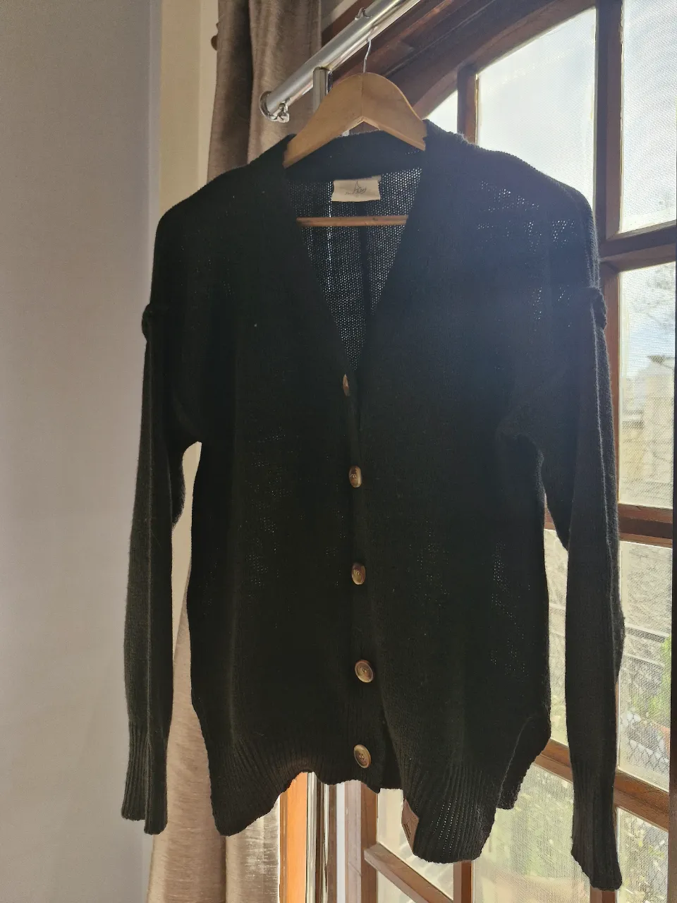 Cardigan negro de tejido suave con botones. Ideal para un look casual y abrigado, gruesito.