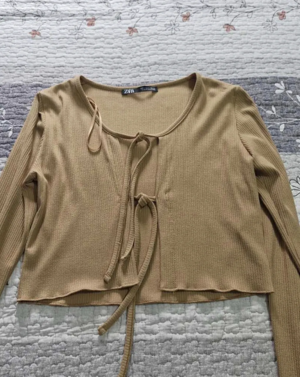 Top manga larga con detalle de lazo en el frente. Ideal para un look casual y moderno. Marca ZARA.