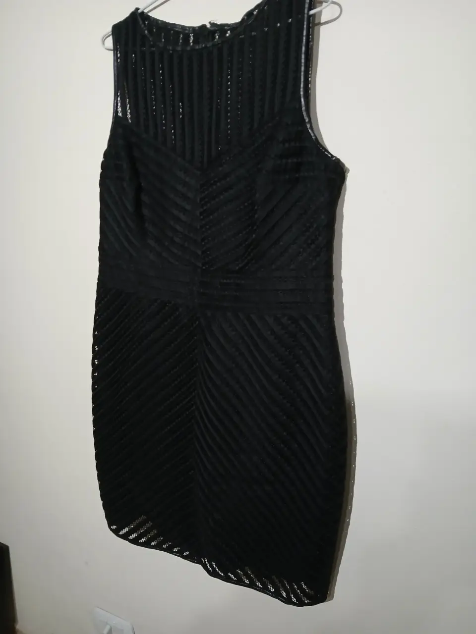Vestido midi negro con diseño geométrico y detalles calados. Ideal para eventos formales o fiestas.