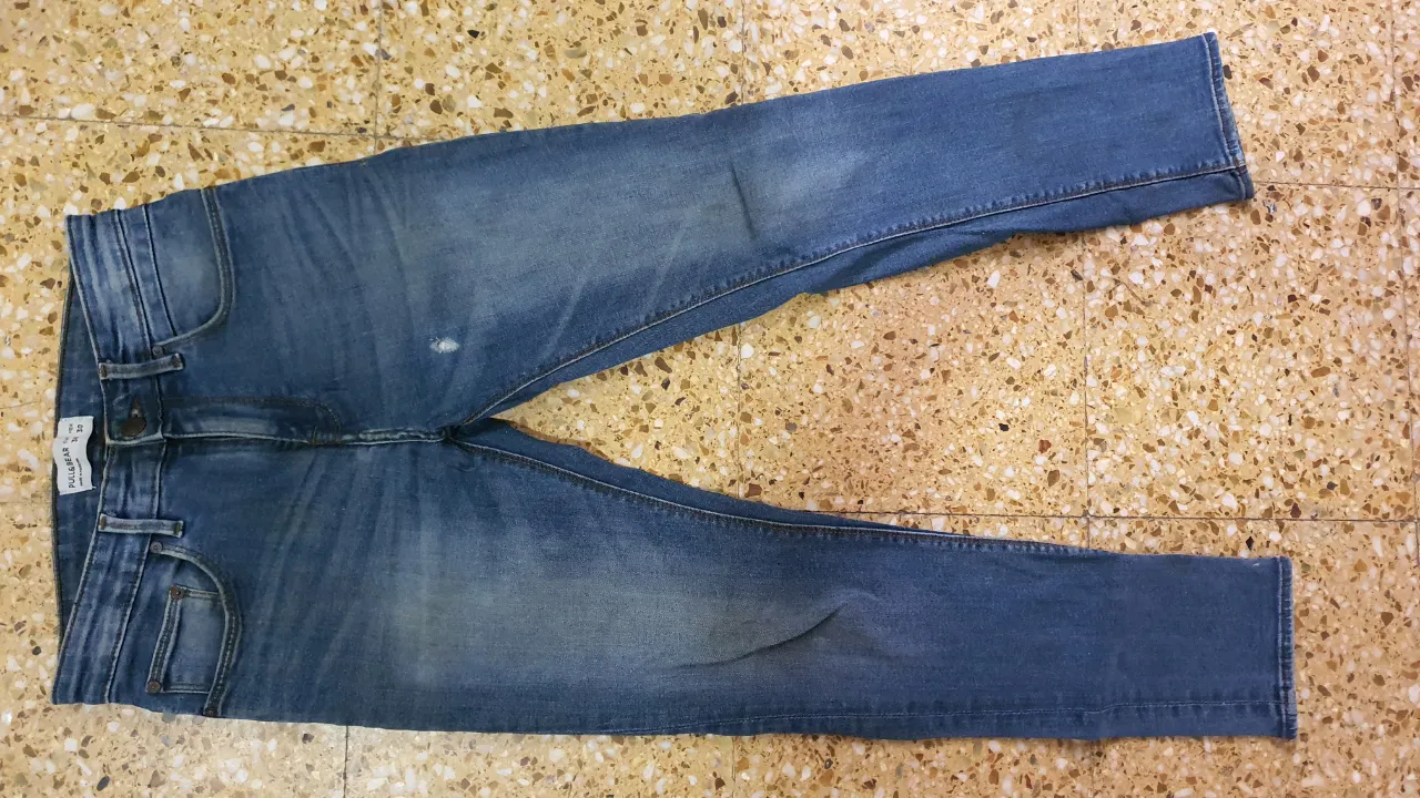 Jeans rectos de hombre, color azul, de la marca Pull&Bear. Talle 38/30, con etiqueta visible. Hecho en Pakistán.