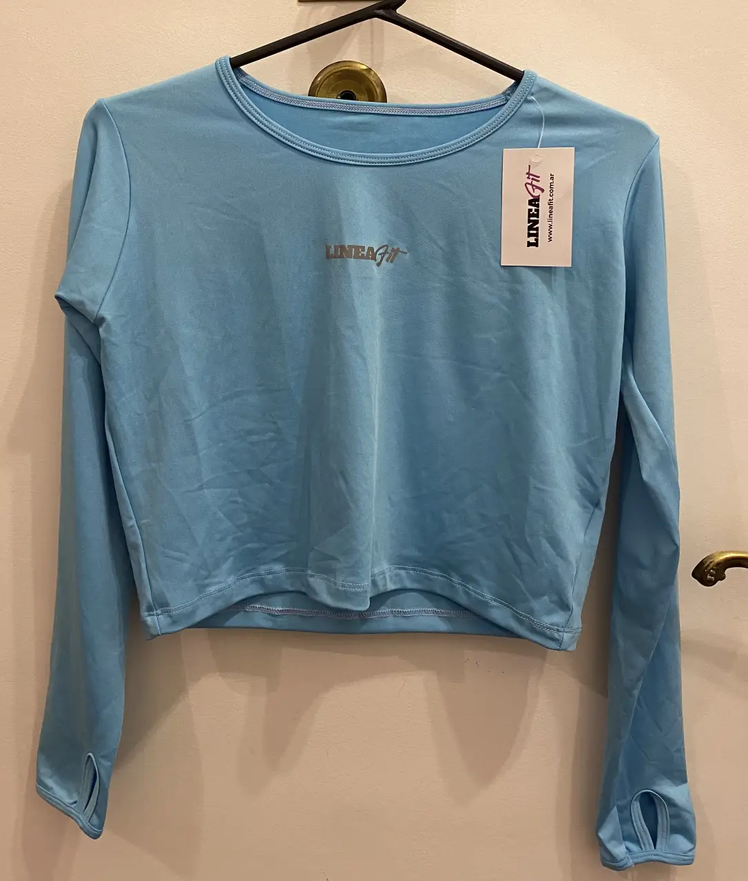 Remera deportiva de manga larga. Medidas aproximadas (tomadas en plano): 44cm ancho, 41 cm largo