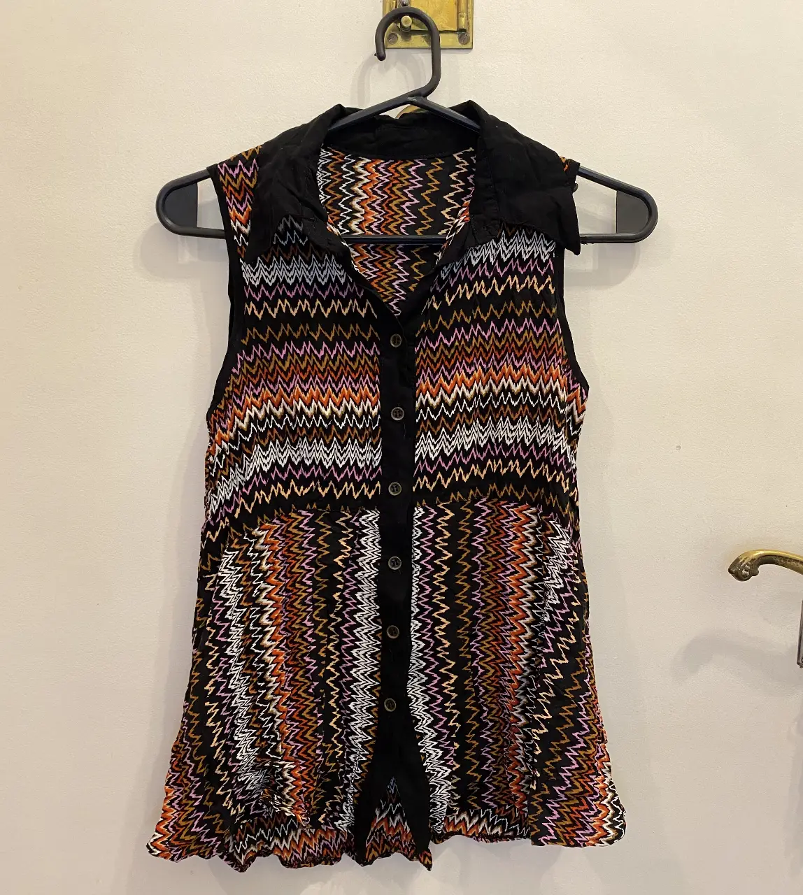 Blusa sin mangas, cuello camisero y botones frontales. Ideal para un look casual y con estilo. Medidas aproximadas (tomadas en plano): 39cm de ancho, 64cm de largo.