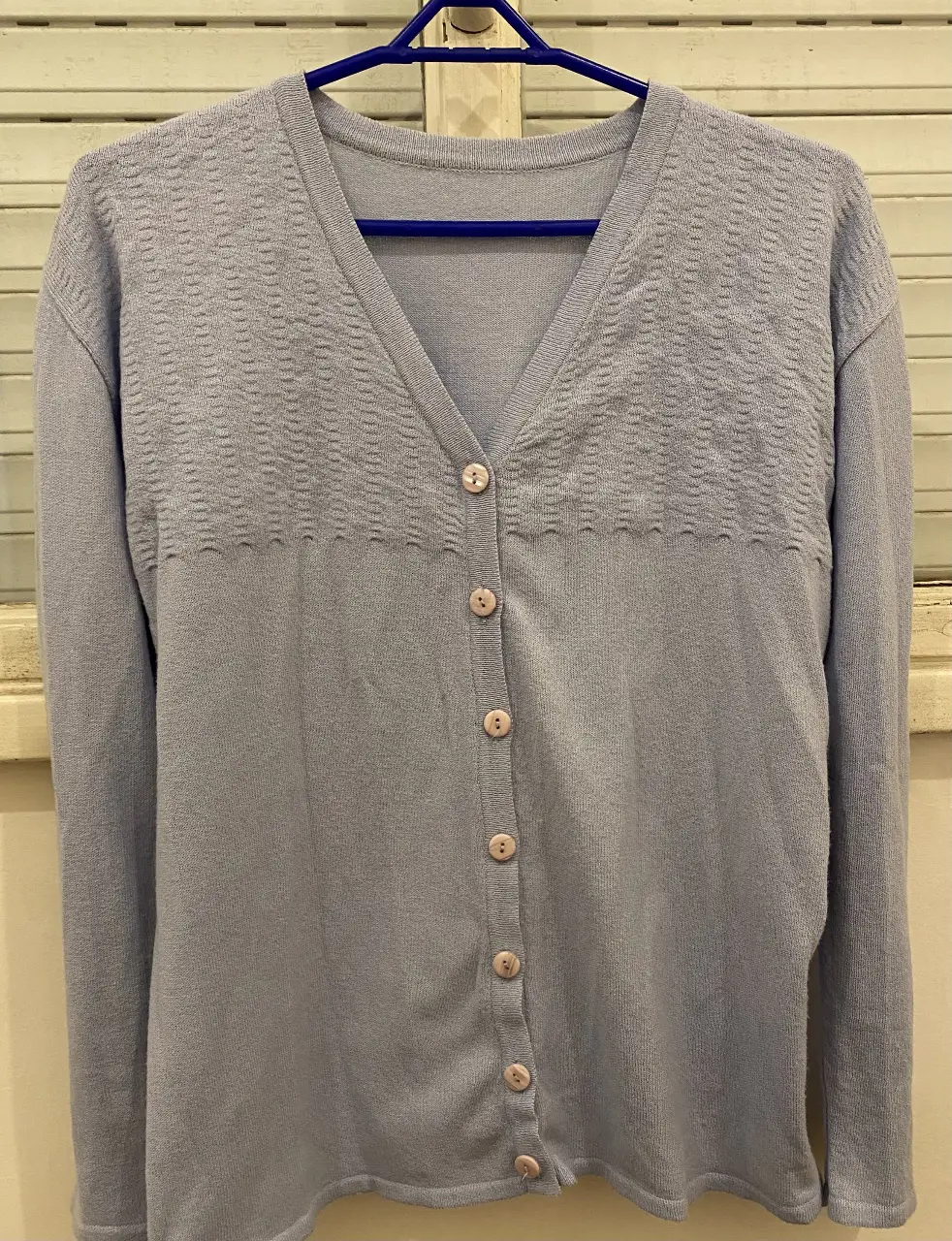 Cardigan de punto azul claro con botones. Ideal para un look casual y cómodo.
